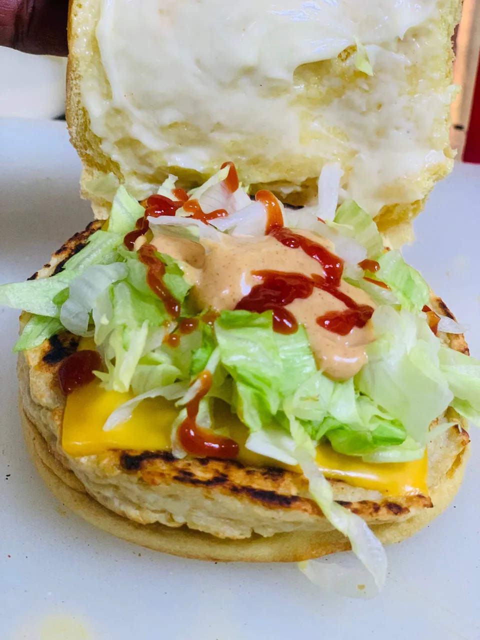 Open chicken burger with cheese, lettuce and two sauces