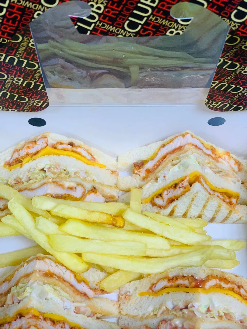 Club sandwich cut into triangles, served with fries