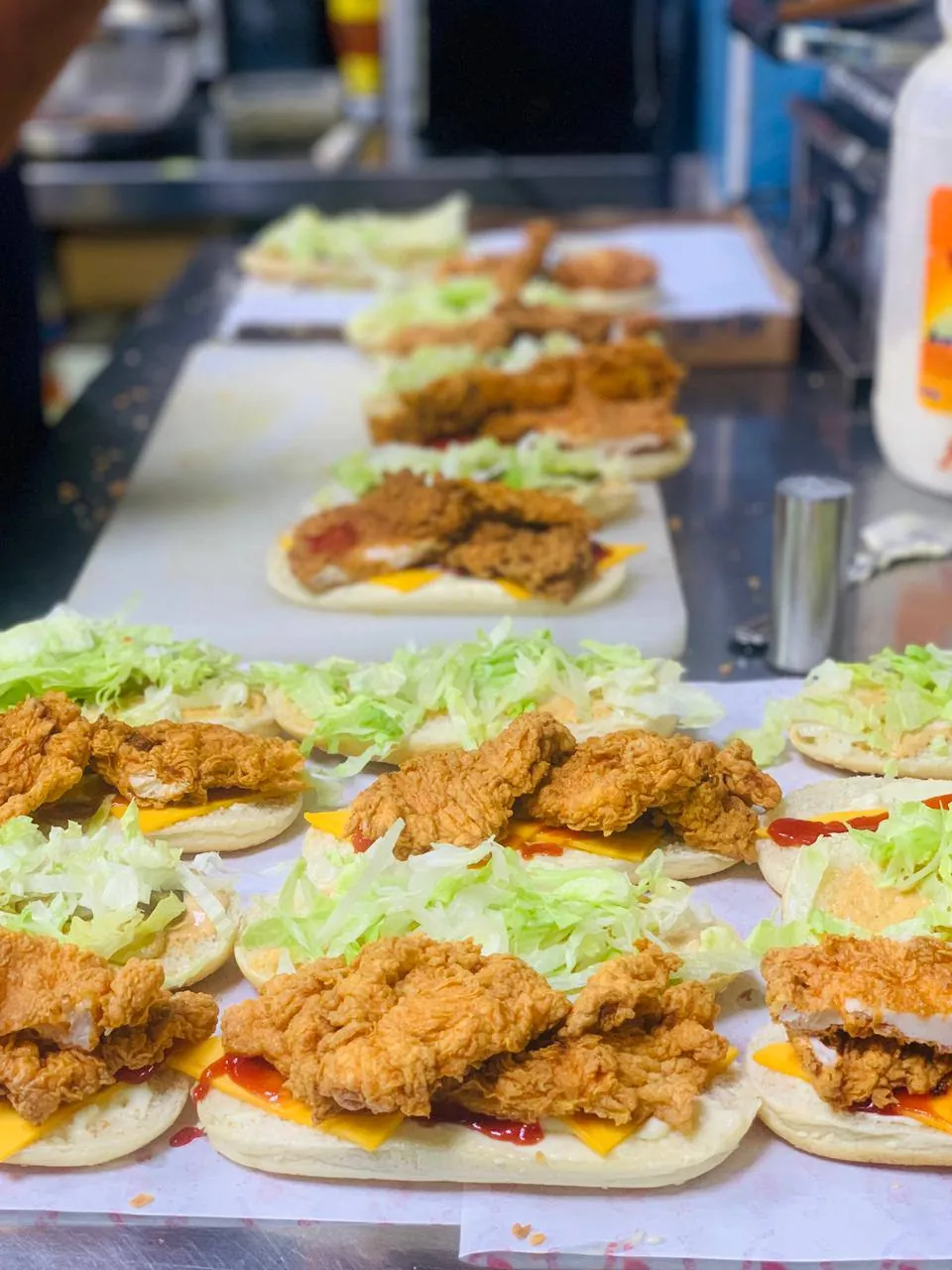 Row of chicken sandwiches being assembled at the counter