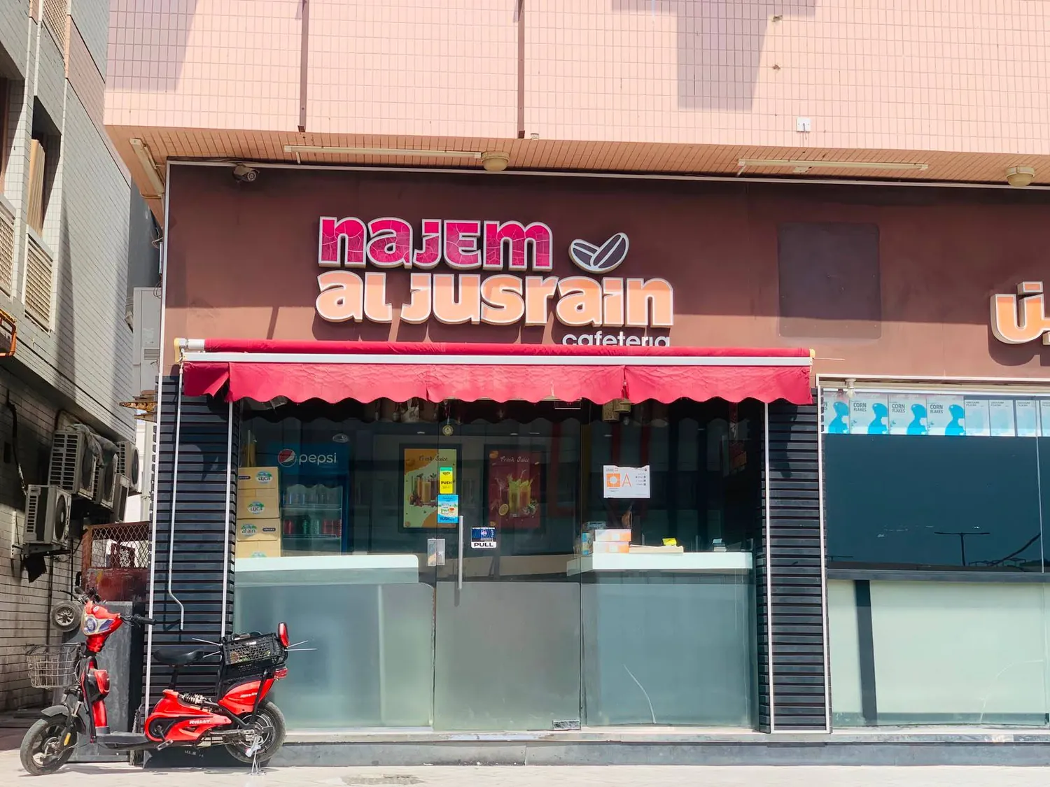 Red awning and service counter at Najem Al Jusrain