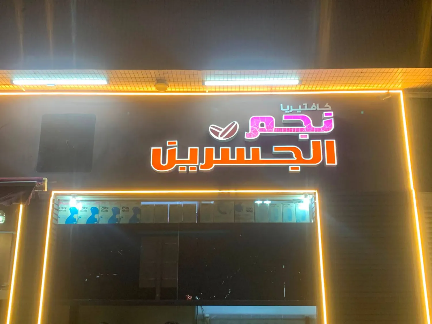Arabic neon sign of Najem Al Jusrain at night
